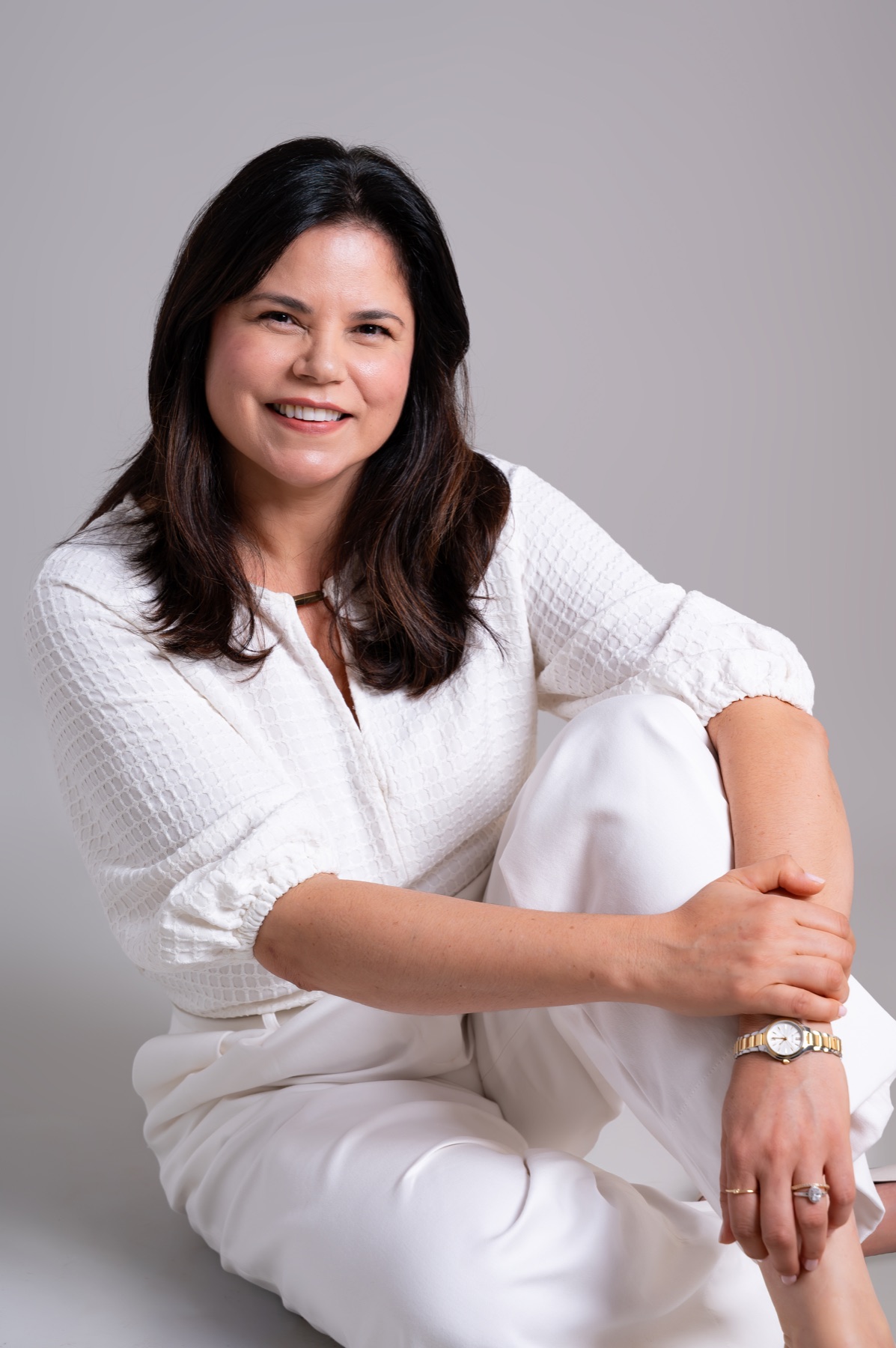 Dra. Andrea Pinhatti sentada em retrato profissional